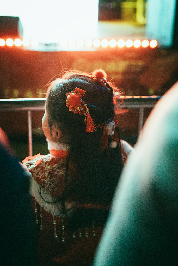 little girl dressed up looking at chinese new year celebrations