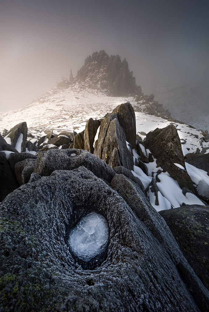 landscape photo taken in snowdonia with light grey rock in foreground mountain in background