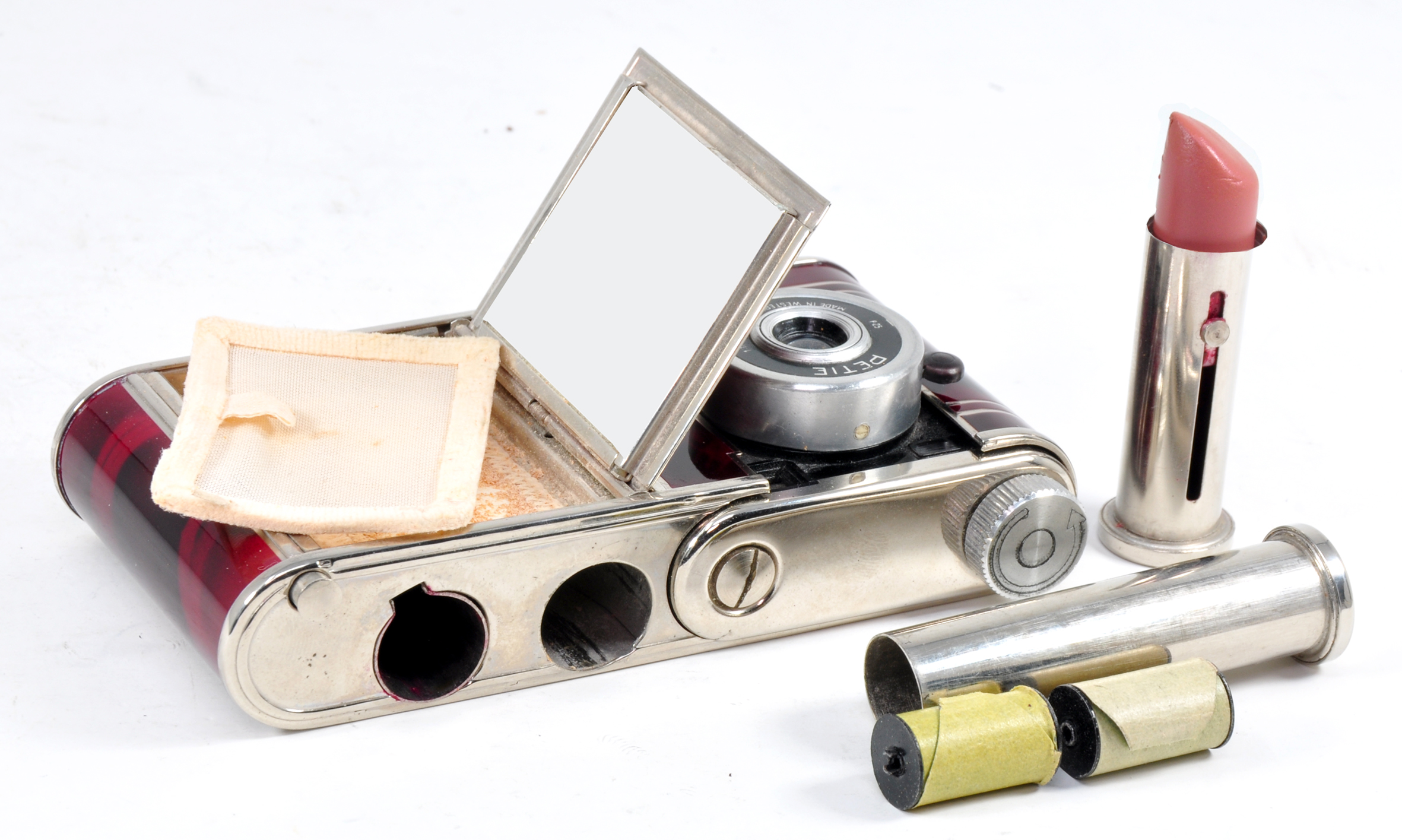 The Vanity as powder compact with its compartment for face powder open, a container for lipstick and another to hold spare films, both withdrawn from the camera’s top plate