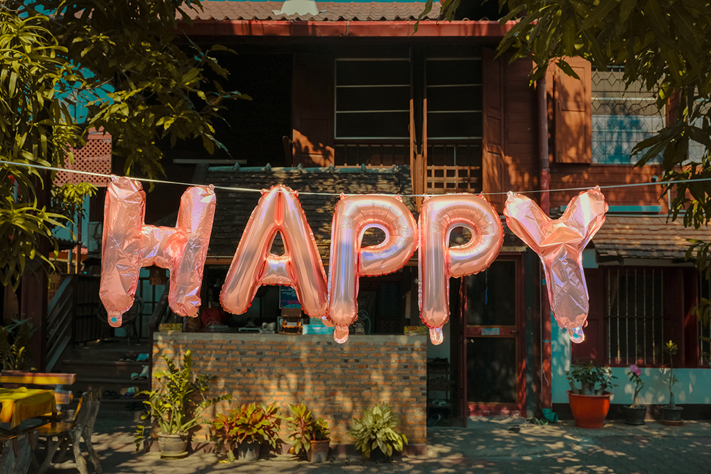 photo of 'happy' balloon letters hanging in the street
